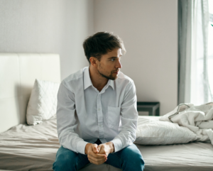 man sitting alone on a bed